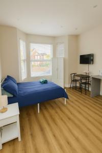 a bedroom with a blue bed and a desk at 58 Stylish Acton Studio Fast Central Connection in London