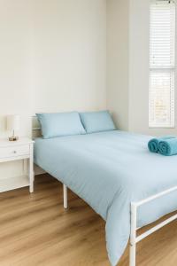 a bed in a white room with a white table at 58 Stylish Acton Studio Fast Central Connection in London