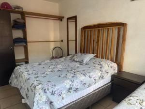a bedroom with a bed with a wooden headboard at Habitación en casa familiar in Antigua Guatemala