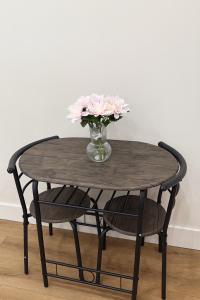 a wooden table with a vase of flowers on top at 58 Stylish Acton Studio Fast Central Connection in London