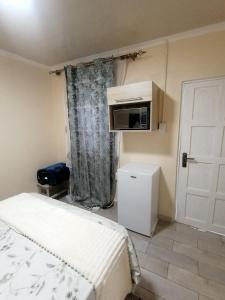 a small room with a bed and a microwave at Hospital View Residence in Boksburg
