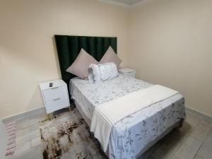 a small bedroom with a bed and a night stand at Hospital View Residence in Boksburg