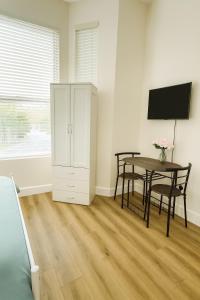 a dining room with a table and a tv at 58 Stylish Acton Studio Fast Central Connection in London