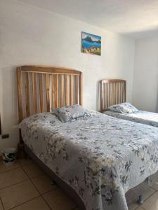 a bedroom with two beds in a room at Habitación en casa familiar in Antigua Guatemala