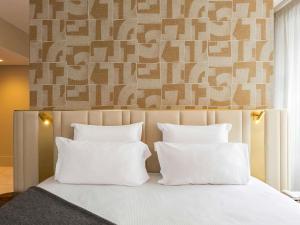 a bedroom with a bed with white pillows at Le Saint Gervais Hotel & Spa Handwritten Collection in Saint-Gervais-les-Bains