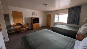 a hotel room with two beds and a desk at Himont Motel in Fall River Mills