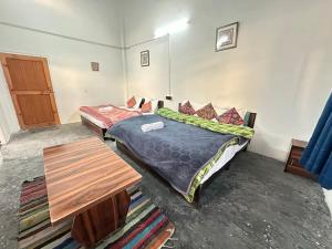 una camera con due letti e un tavolo in legno di High on hills a Kalgha Altre 17 foto