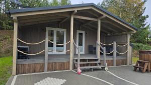 a small building with a porch and a bench at Studniarskie Zacisze - domek Moringa in Borzechowo