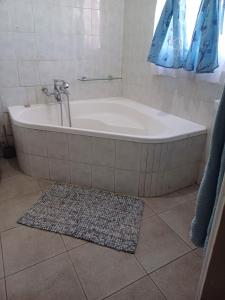 een bad in de badkamer met een tapijt bij Serene on 5 Cologne in Germiston