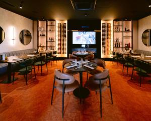 a restaurant with tables and chairs and a flat screen tv at Harmony Space Apartment in Banja Luka