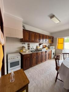 a large kitchen with wooden cabinets and a table in it at Casa Macedo in Vila Real de Santo António