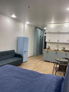 une chambre avec un lit, un canapé et une cuisine dans l'établissement NBG Aparthotel, à Batoumi