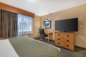 a hotel room with a bed and a flat screen tv at Best Western Sicamous Inn in Sicamous