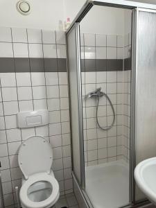 une salle de bains avec douche, toilettes et lavabo dans l'établissement Zimmer, à Vienne