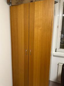 une armoire en bois dans une chambre avec fenêtre dans l'établissement Zimmer, à Vienne