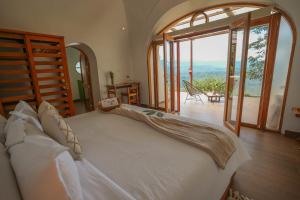 a bedroom with a large bed with a large glass door at Vibra Wellness Hotel y Spa in Teniente Hugo Ortiz