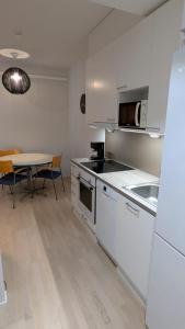 a kitchen with white cabinets and a table with a tableablish at Apartment Riistavalkea in Rovaniemi