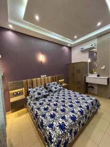 a bedroom with a bed with a blue and white blanket at EZK Appart in Kika