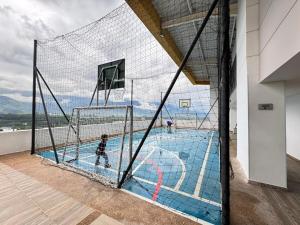 a basketball hoop with two boys playing in a pool at Fundadores Apartment with balcony, pool, gym in Armenia