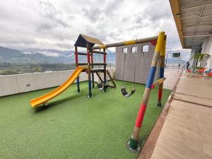 a playground with a slide on a roof at Fundadores Apartment with balcony, pool, gym in Armenia