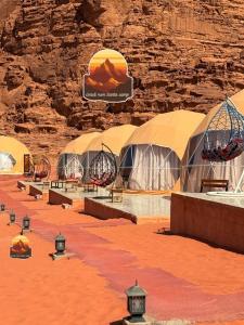 a group of domes in a desert with a stone wall at Wadi Rum Santa Camp in Wadi Rum