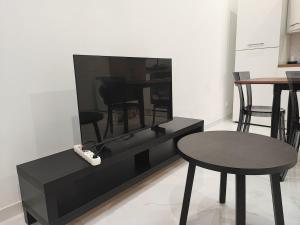 a living room with a tv and a table and chairs at A Cozy Loft for You in Conflans-Sainte-Honorine