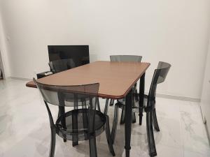 a wooden table with black chairs in a room at A Cozy Loft for You in Conflans-Sainte-Honorine