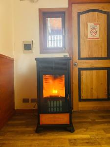 a wood burning stove in a room with a door at Hotel California in Temuco