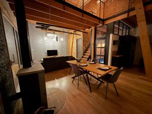 a dining room and living room with a table and chairs at Le Chalet des Vosges in Anould