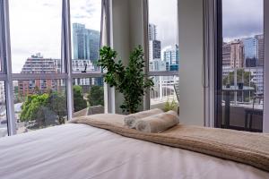 a bedroom with large windows and a bed with two towels at The Lookout in Cape Town
