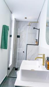 a white bathroom with a shower and a sink at The Lookout in Cape Town