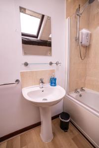 a bathroom with a sink and a mirror and a tub at The Granary in Bampton +13 photos