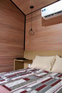 ein Schlafzimmer mit einem Bett mit einer Holzwand in der Unterkunft Premium Black in Canela