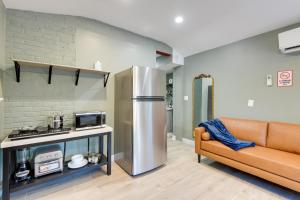 a kitchen with a stainless steel refrigerator and a couch at Walk to Metro Station! Cheverly Apt 8 Mi to DC in Cheverly