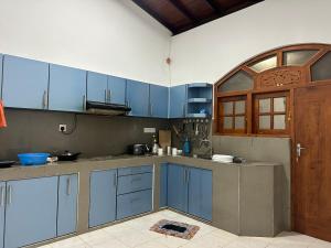 a kitchen with blue cabinets and a wooden door at Kashmir villa in Galle