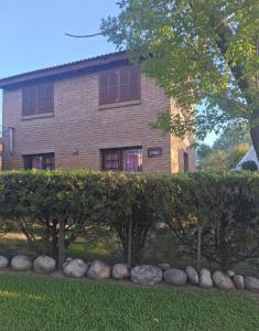 ein Haus mit einer Hecke vor einem Gebäude in der Unterkunft La casa de Milac in Mina Clavero