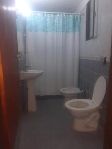 ein Badezimmer mit Toilette und Waschbecken in der Unterkunft La casa de Milac in Mina Clavero