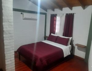 a bedroom with a large bed with a red blanket at La casa de Milac in Mina Clavero