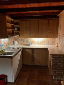 a kitchen with wooden cabinets and a sink and a counter at Fengselet Gjestegård in Leira