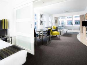 um quarto de hotel com uma cama, uma mesa e cadeiras em Mantra on Kent em Sidney