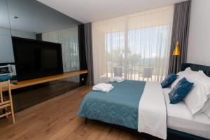 une chambre avec un grand lit et une télévision à écran plat dans l'établissement Empire Beach Resort ADULTS ONLY, à Dhërmi 105 autres photos