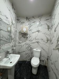 Un baño con un inodoro blanco y un lavabo. en Platinum Apartment, en Rawalpindi