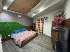 Un dormitorio con una cama con una pared verde. en Platinum Apartment, en Rawalpindi