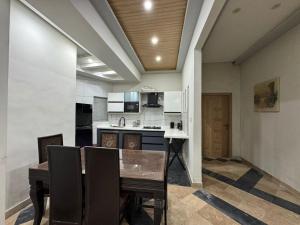 Un comedor con una mesa y una cocina. en Platinum Apartment, en Rawalpindi 39 fotos más