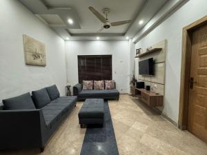 Una sala de estar con un sofá y un televisor. en Platinum Apartment, en Rawalpindi