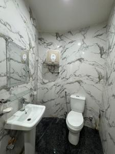 Un baño con un inodoro blanco y un lavabo. en Platinum Apartment, en Rawalpindi