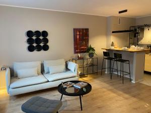 a living room with a white couch and a kitchen at Casa Soden, Artful living just outside the city in Bad Soden am Taunus