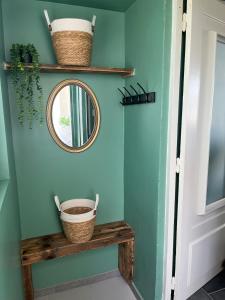 un corridoio con uno specchio e una mensola con cestini di Charmant T2 refait à neuf 1chambre 1 canapé lit dans le bureau et 1 canapé lit dans le salon a Saint-Nicolas-de-Port