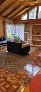a living room with a couch on a wooden floor at Aves & árboles Casa 7p piscina y fogón in El Cerrillo