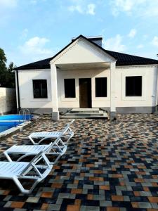 ガルニにあるWhite house Garniのラウンジチェア2脚とスイミングプールが備わる家